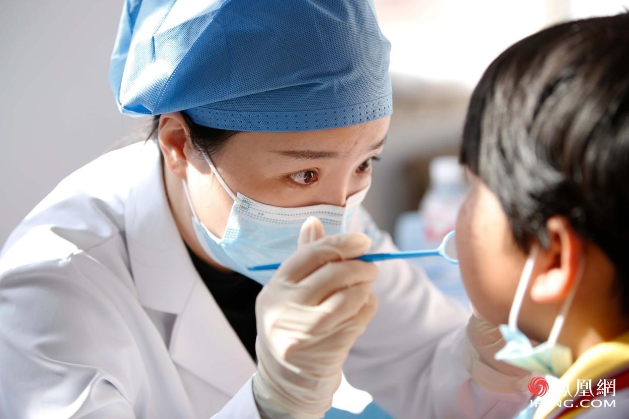 志愿者为孩子进行口腔检查